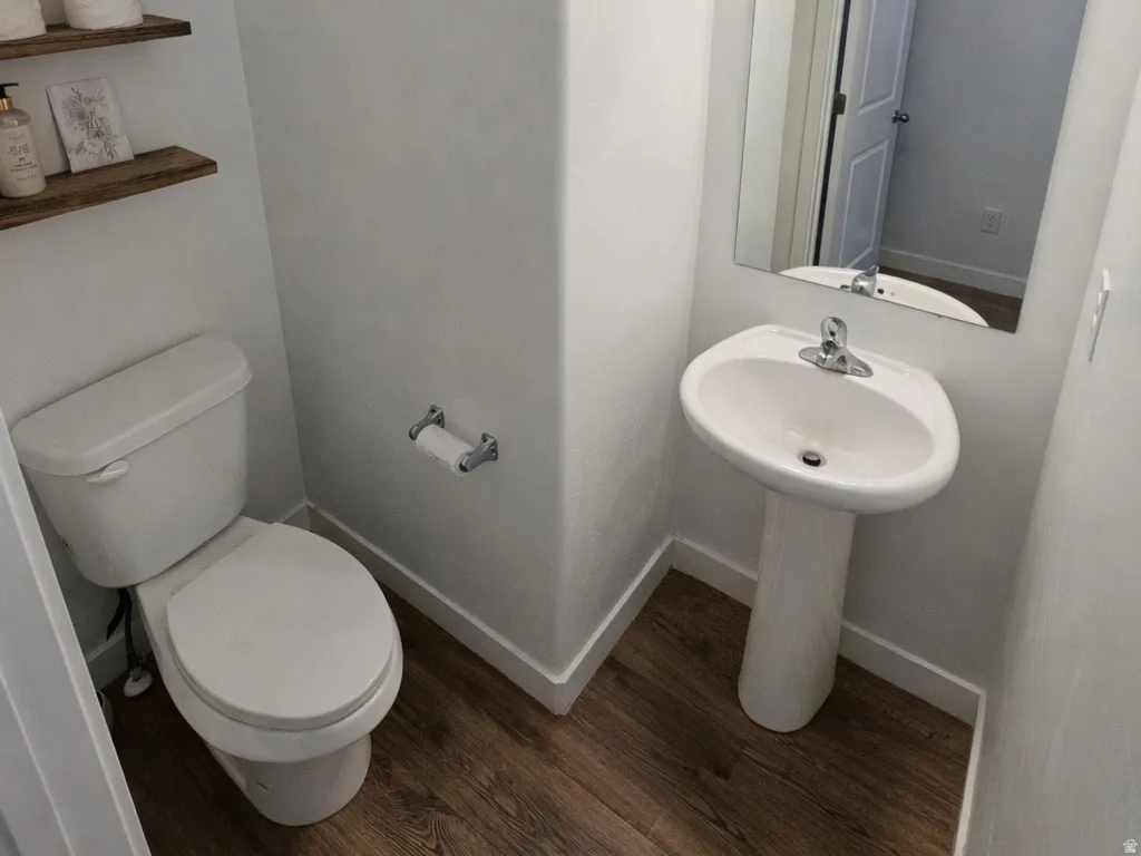 Bathroom featuring toilet and dark wood-type flooring