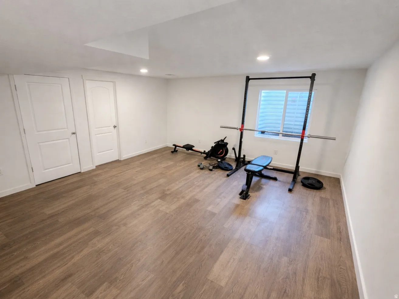 Workout room with wood finished floors and recessed lighting