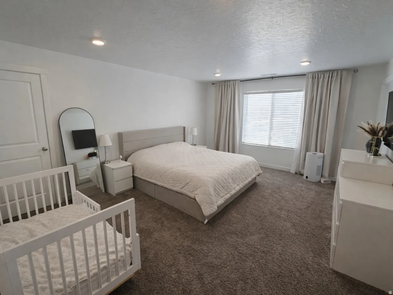Bedroom featuring a textured ceiling and dark carpet