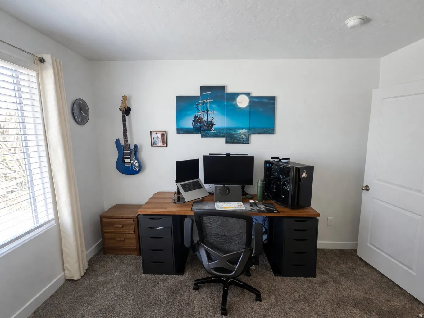 Office with dark carpet and a textured ceiling