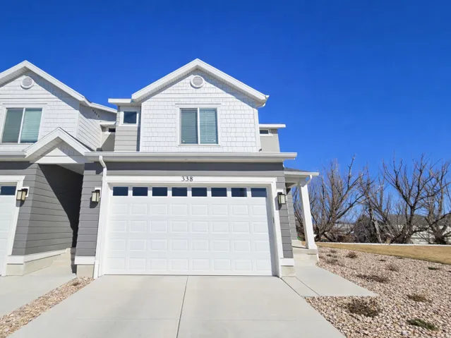 View of front of home with a garage and concrete driveway