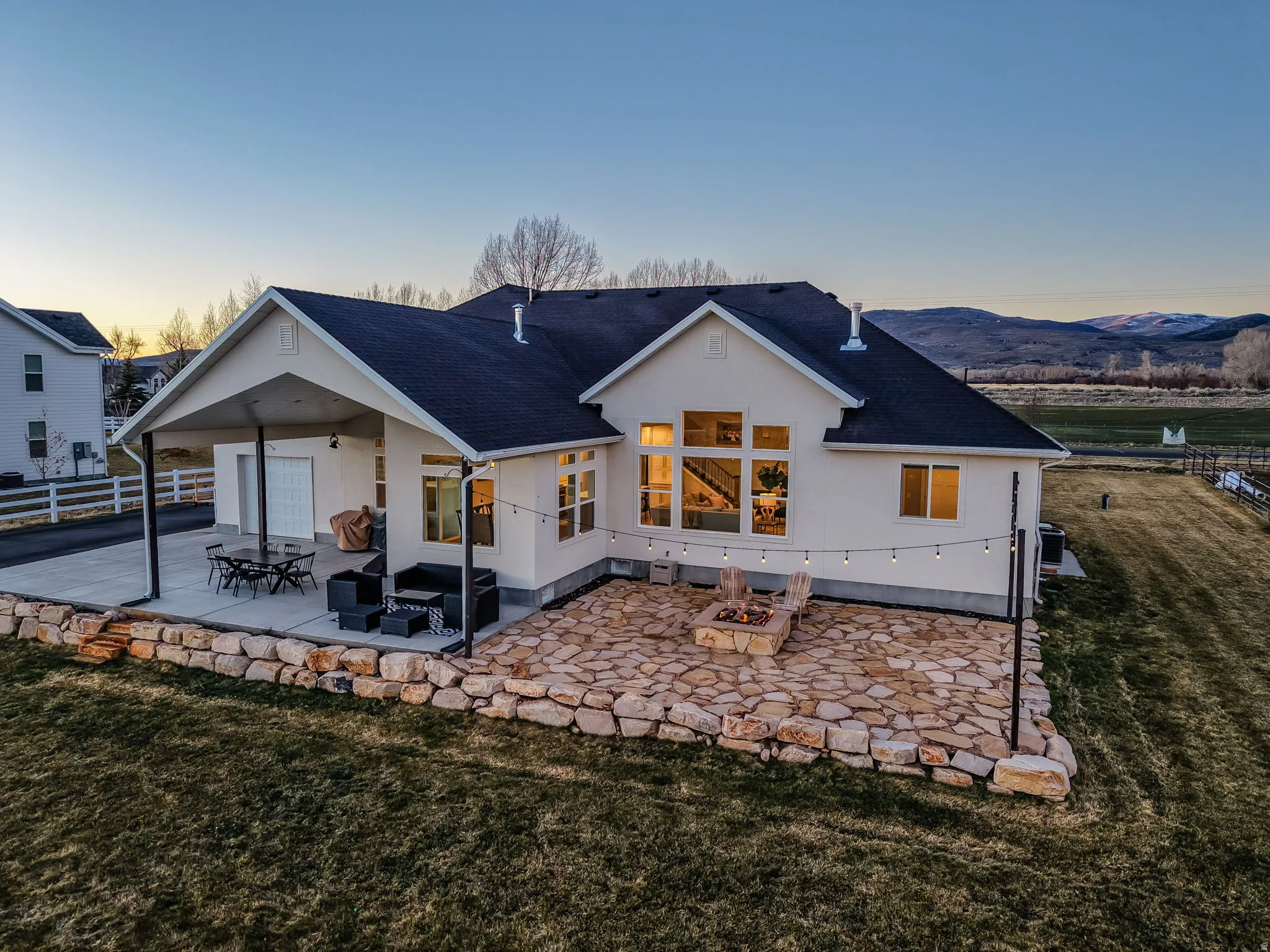Back of house featuring a patio, a shingled roof, and stucco siding