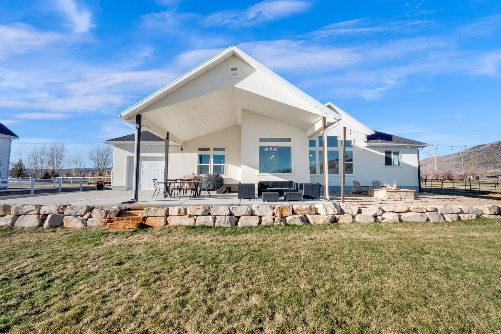 Back of property featuring a patio, stucco siding, an outdoor lounge area, and a garage