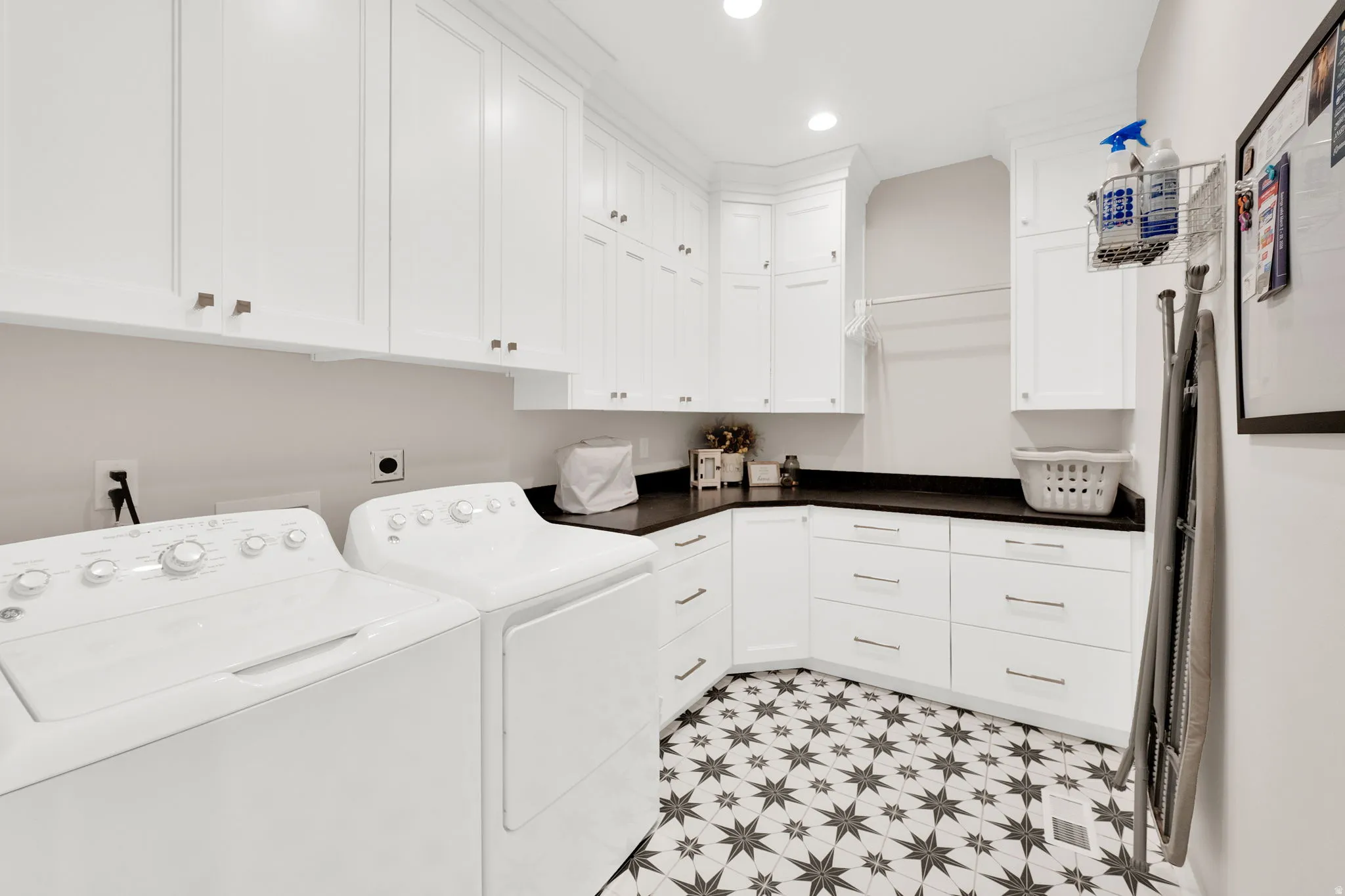 Laundry area featuring recessed lighting, cabinet space, washer and dryer, and light flooring