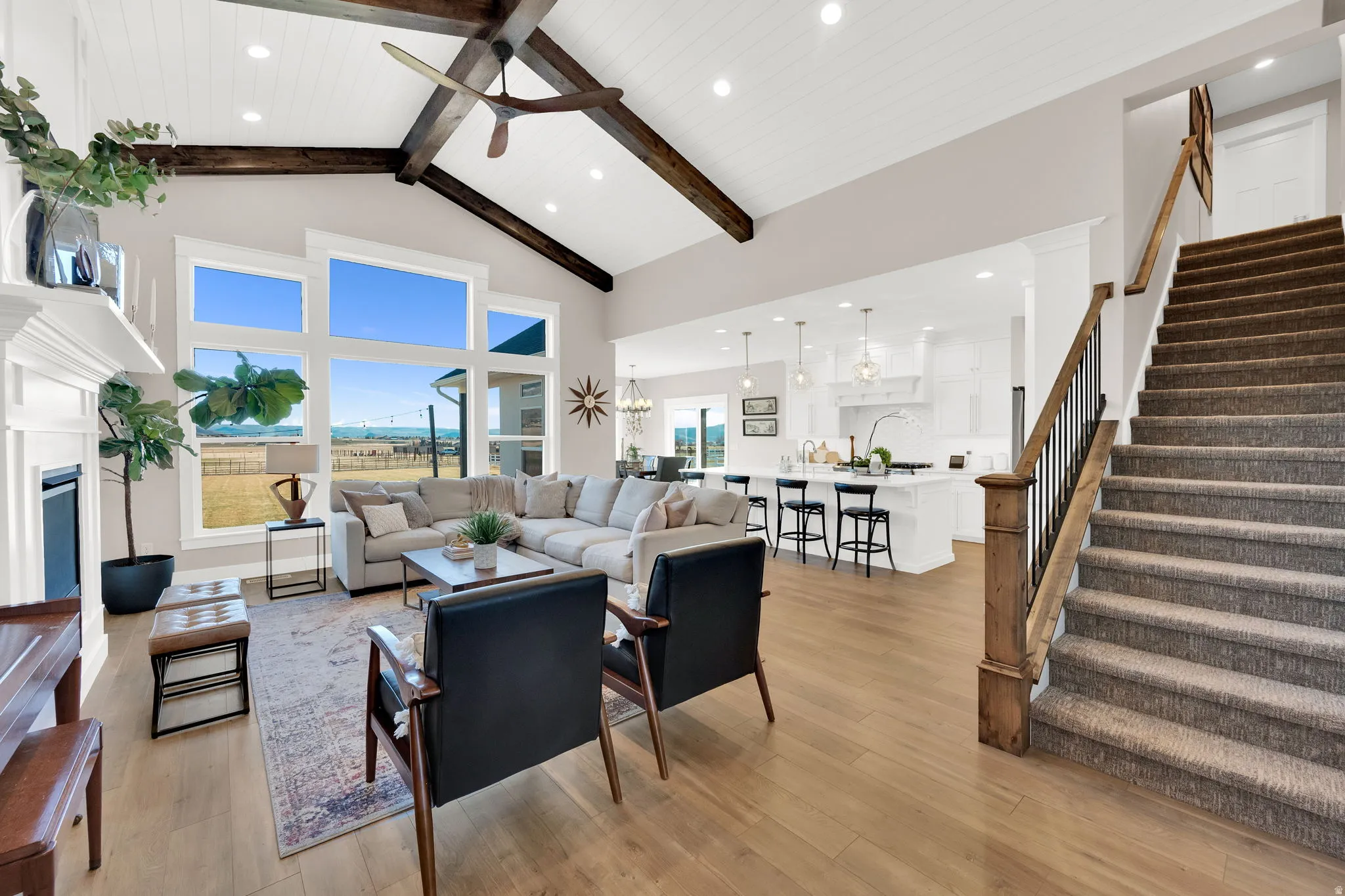 Living area featuring ceiling fan, a fireplace, light wood-style flooring, and hanging lights