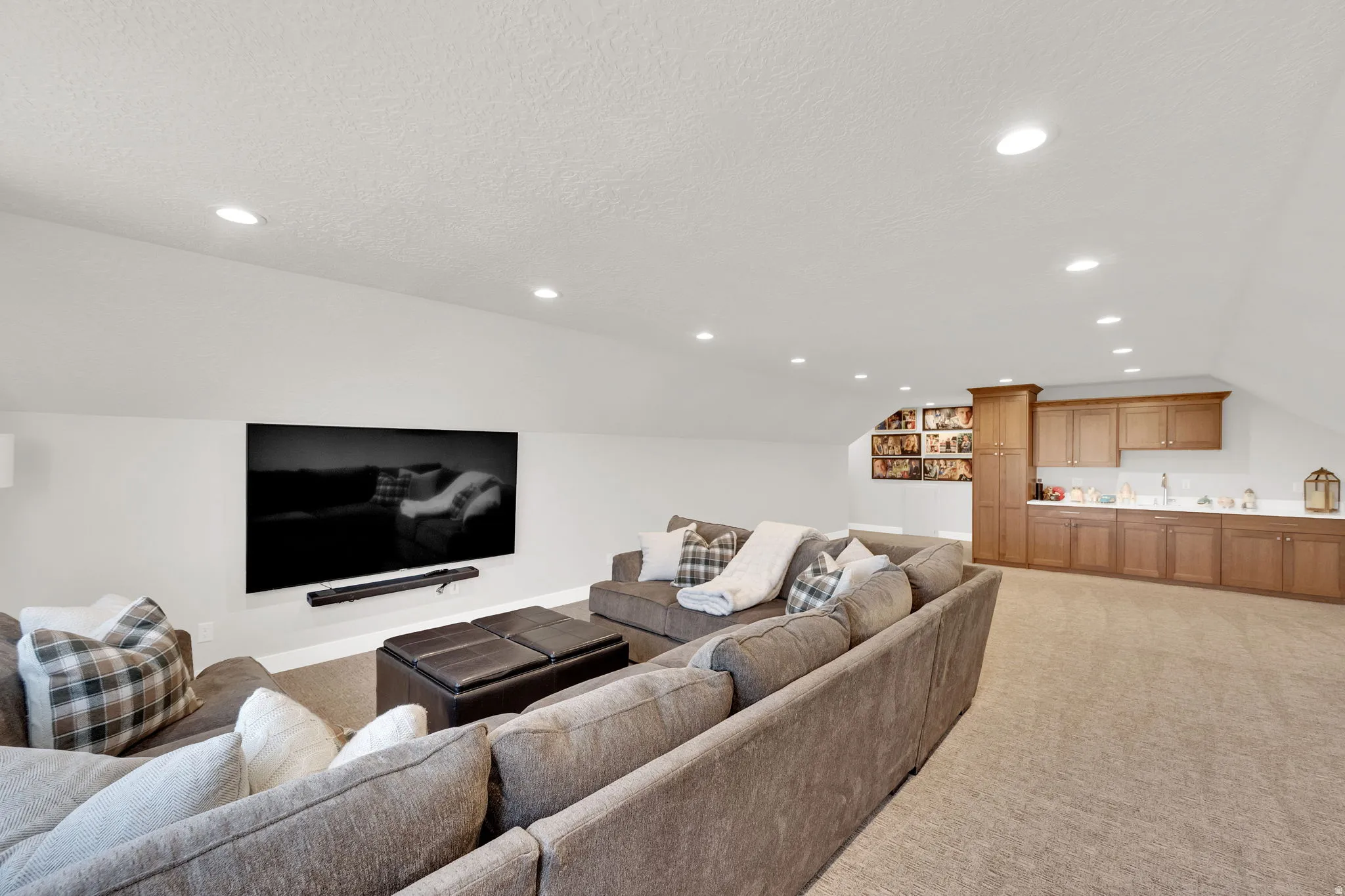 Living area featuring light colored carpet and recessed lighting