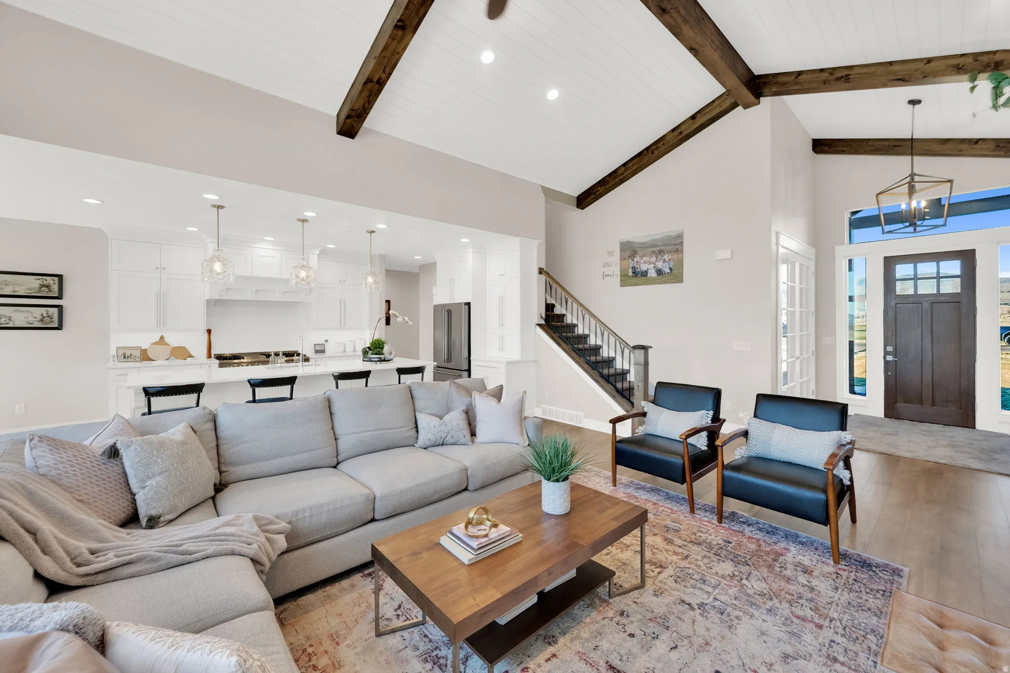 Living room featuring light wood-style flooring, lofted ceiling, and hanging lights