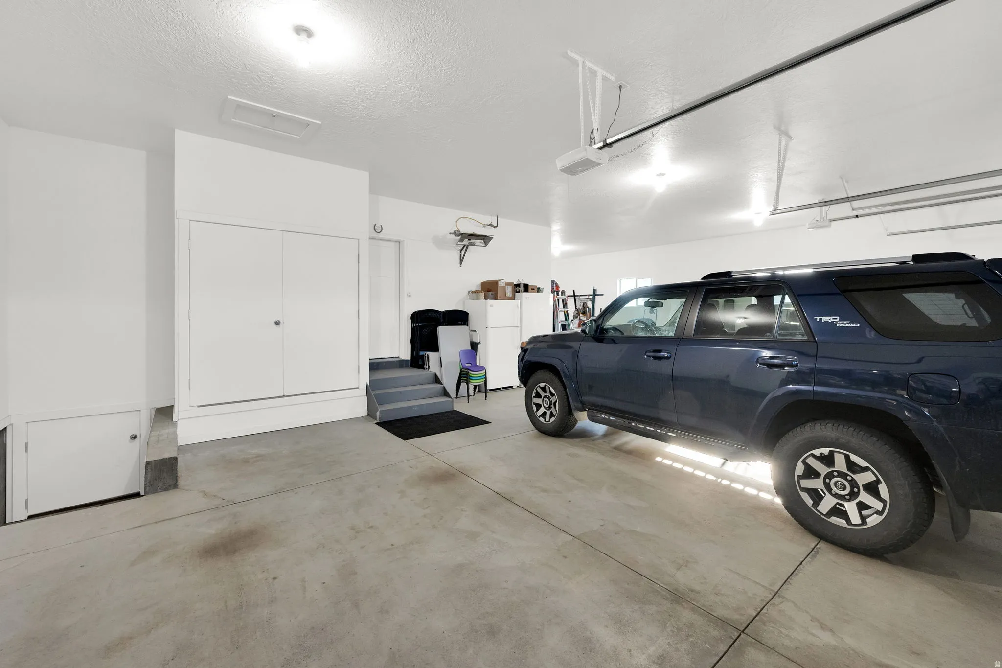 Garage featuring freestanding refrigerator