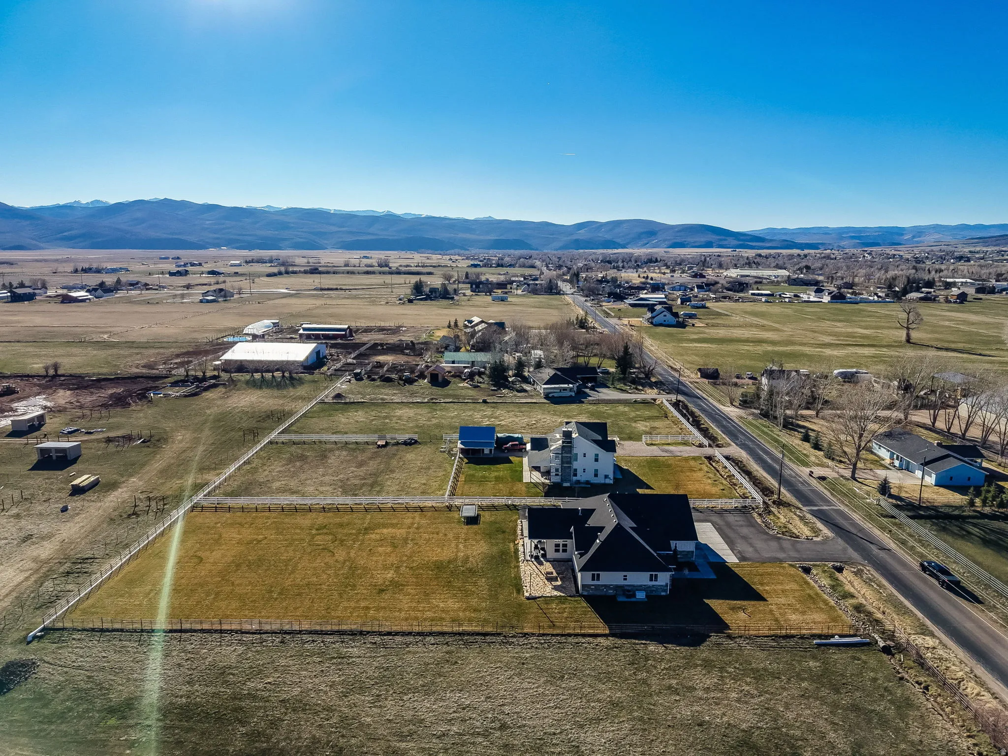 Aerial view of property and surrounding area featuring a mountainous background and rural landscape