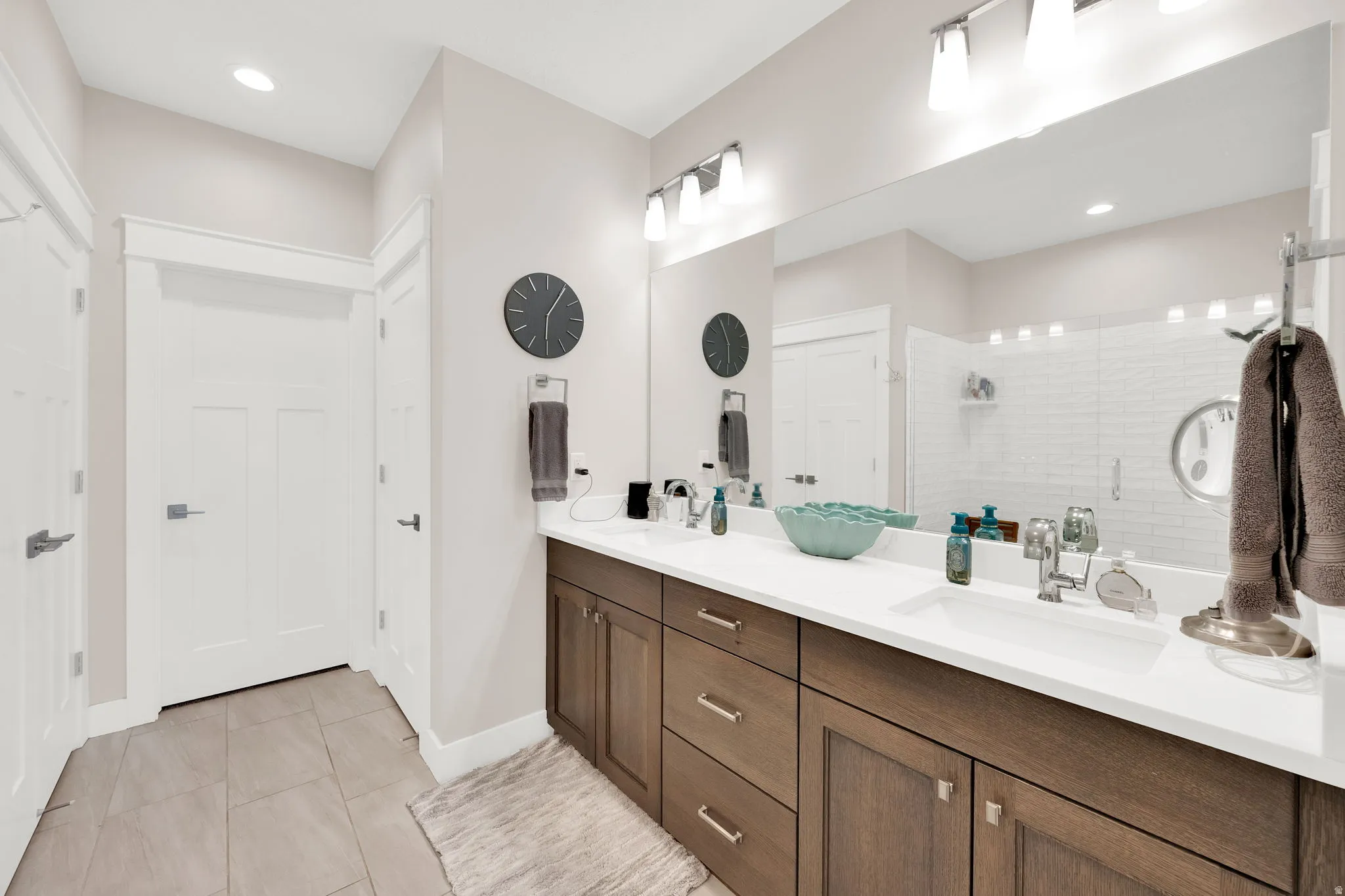 Bathroom featuring double vanity, a stall shower, recessed lighting, and light tile patterned floors