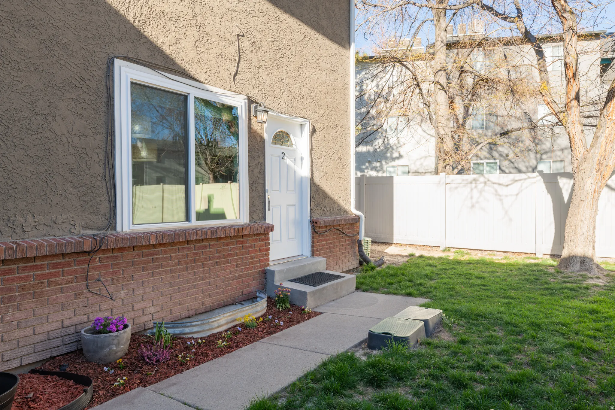 Doorway to property featuring stucco and brick siding.