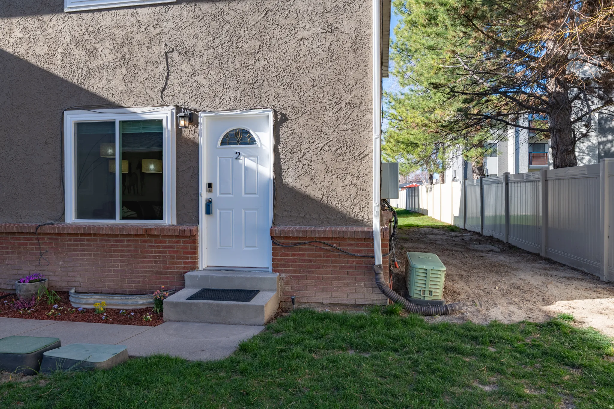 Doorway to property featuring stucco and brick siding.