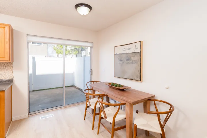 Dining space featuring light wood looking floors & sliding glass door.