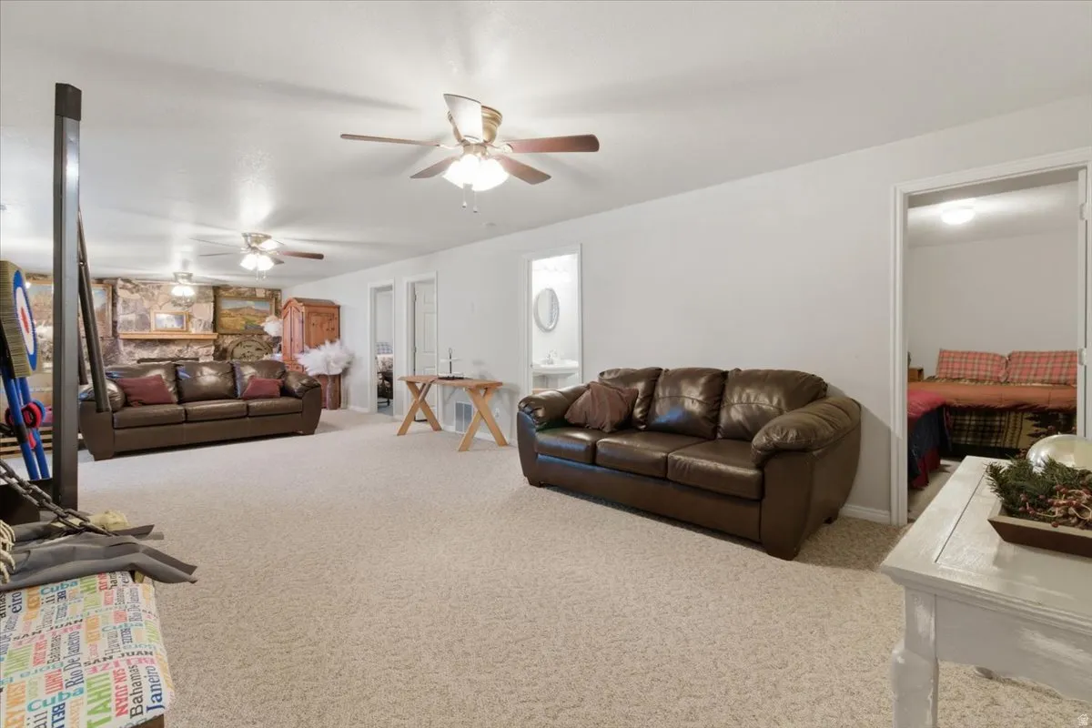Carpeted living area with baseboards and ceiling fan