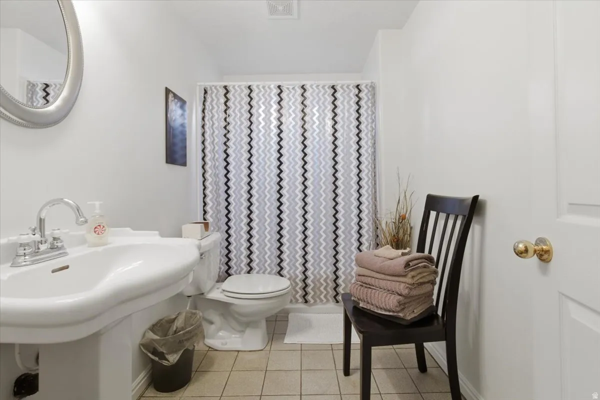 Full bathroom with a shower with curtain and light tile patterned floors