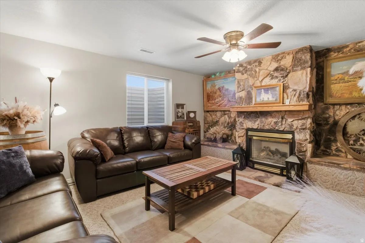 Living room with a ceiling fan and a fireplace
