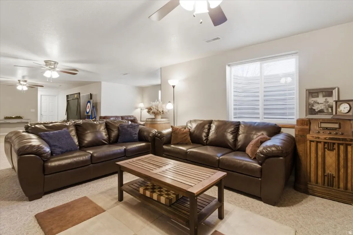 Living room featuring ceiling fan and light carpet