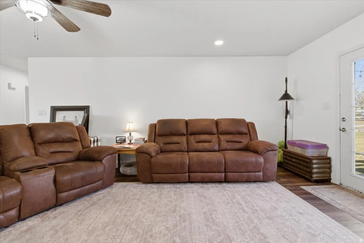 Living room with wood finished floors, ceiling fan, and recessed lighting