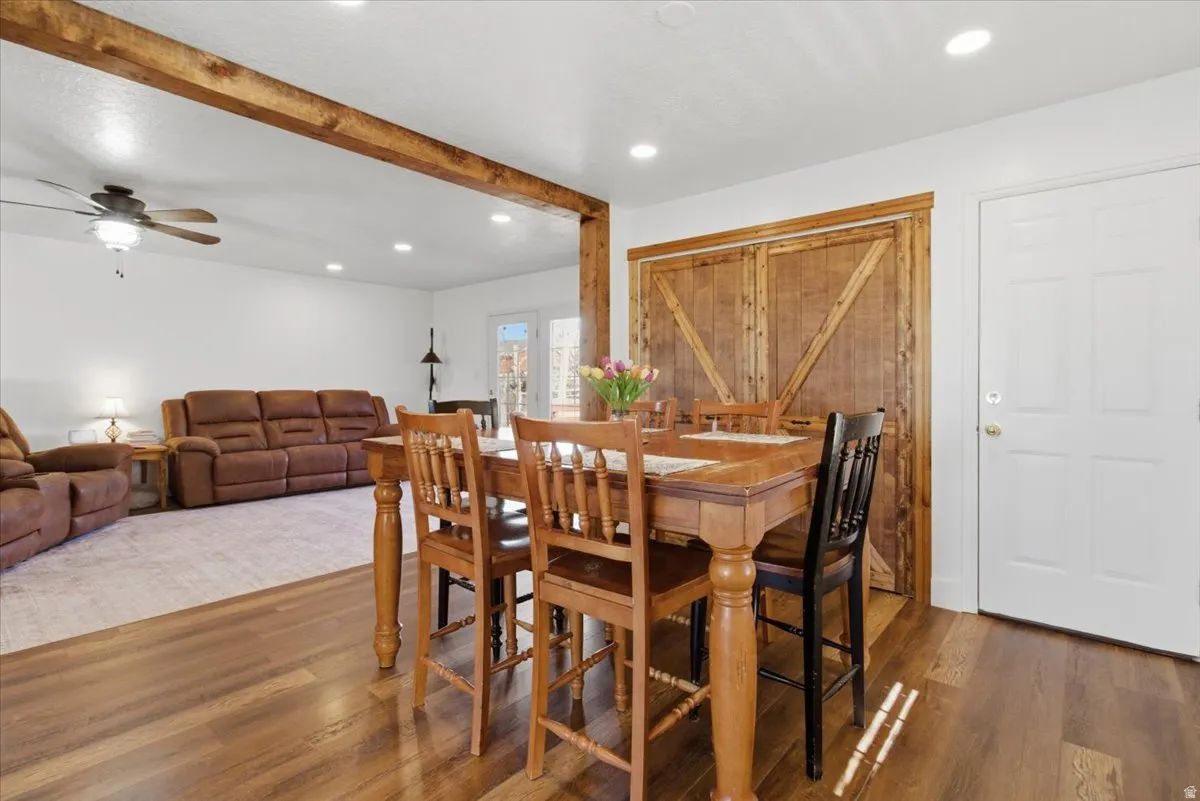 Dining area featuring wood finished floors, ceiling fan, recessed lighting, and beam ceiling