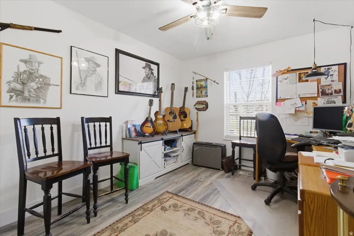 Home office featuring light wood-style floors and a ceiling fan