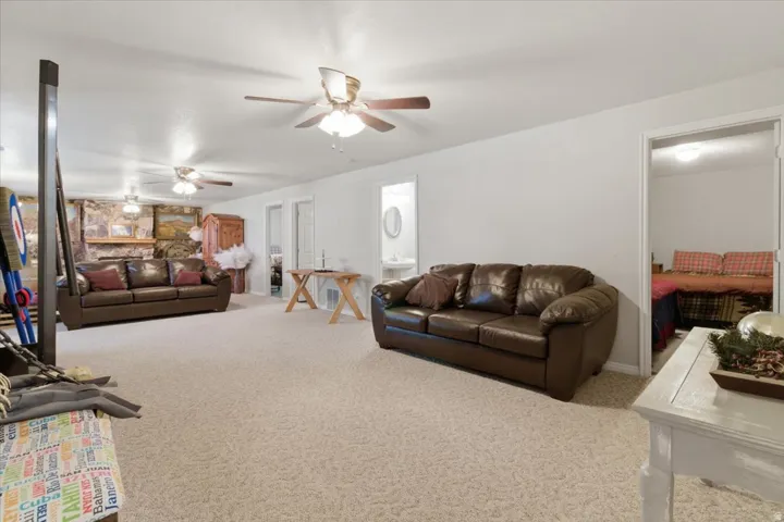 Carpeted living area with baseboards and ceiling fan