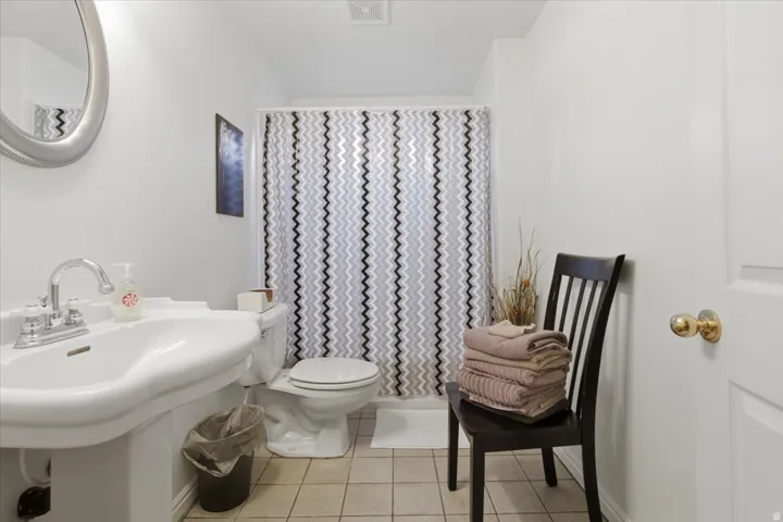 Full bathroom with a shower with curtain and light tile patterned floors