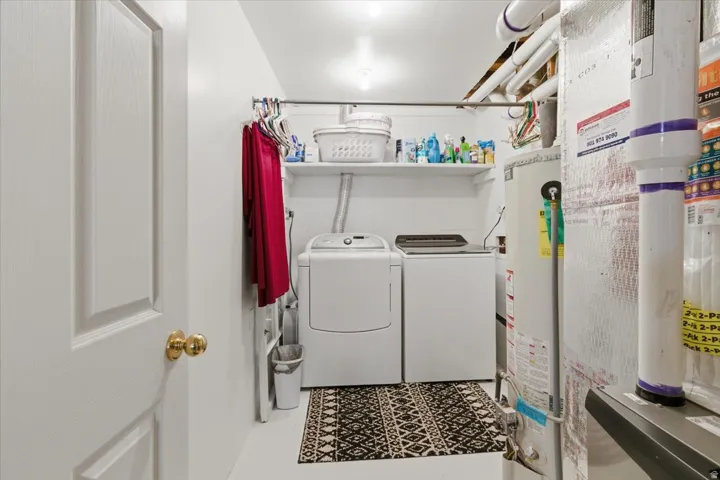 Laundry area with water heater and washer and dryer