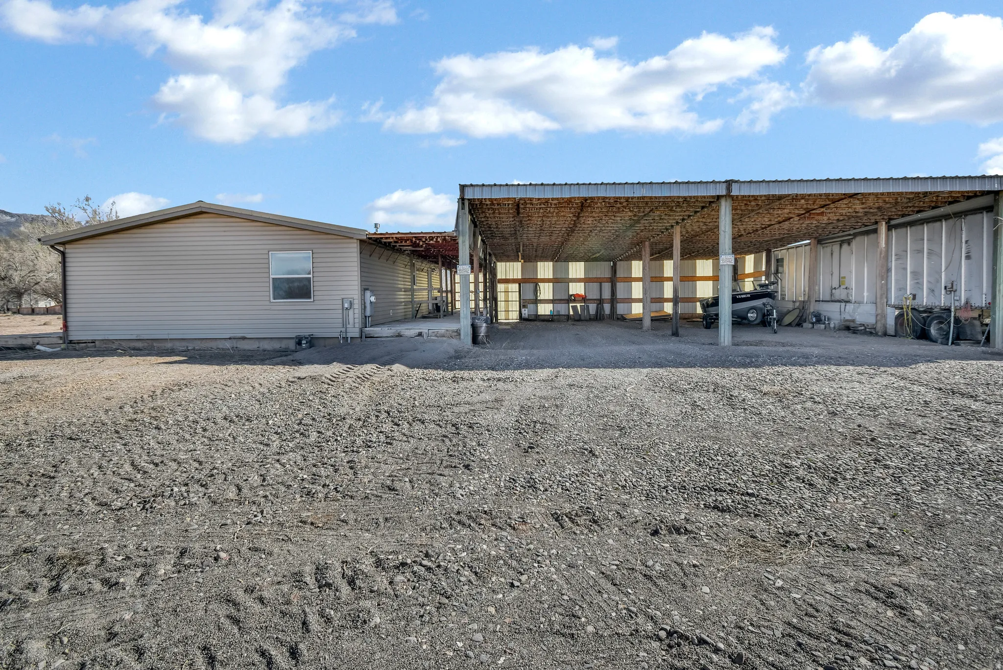 Rear view of property featuring an outdoor structure and a carport