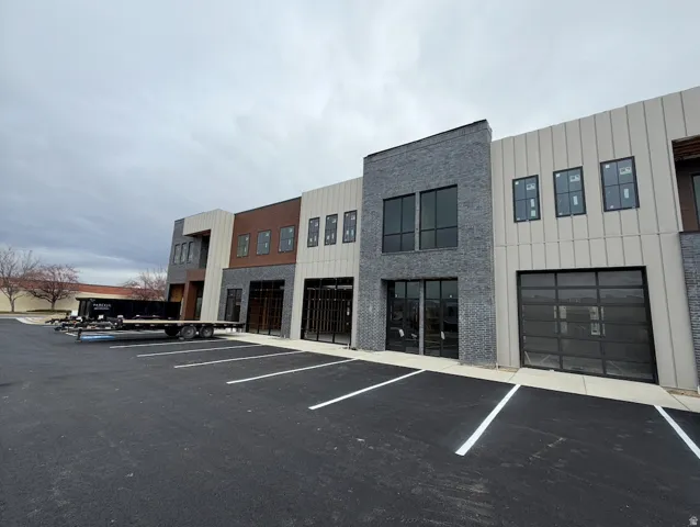 View of building exterior featuring uncovered parking