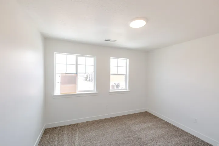 Neutral white walls complement the textured carpet flooring