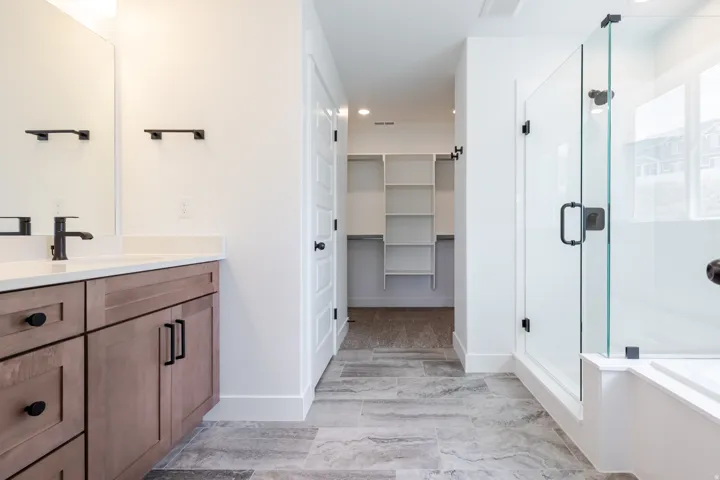 Contemporary bathroom featuring a wood-finish vanity with a white countertop and matte black fixtures