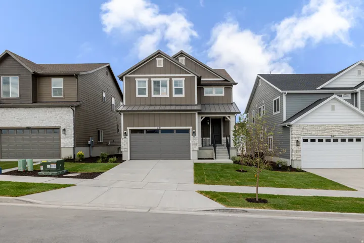 Two-story residential exterior featuring a combination of horizontal siding and stone veneer