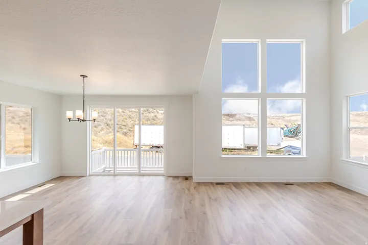 Expansive living area featuring soaring ceilings and large-format wood-finish flooring