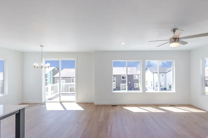 Open-concept interior featuring wood-finish flooring, recessed lighting, and a ceiling fan with integrated light