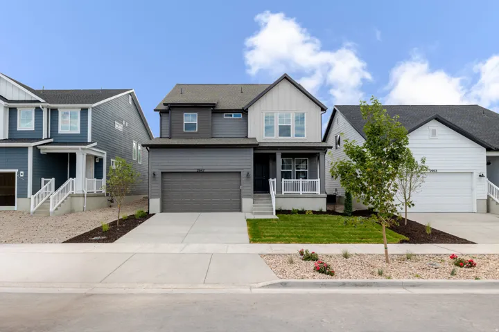 Contemporary two-story residence featuring a two-tone facade with dark gray siding and light gray board and batten accents