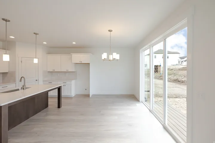 Open-concept kitchen and dining area featuring light wood-finish flooring
