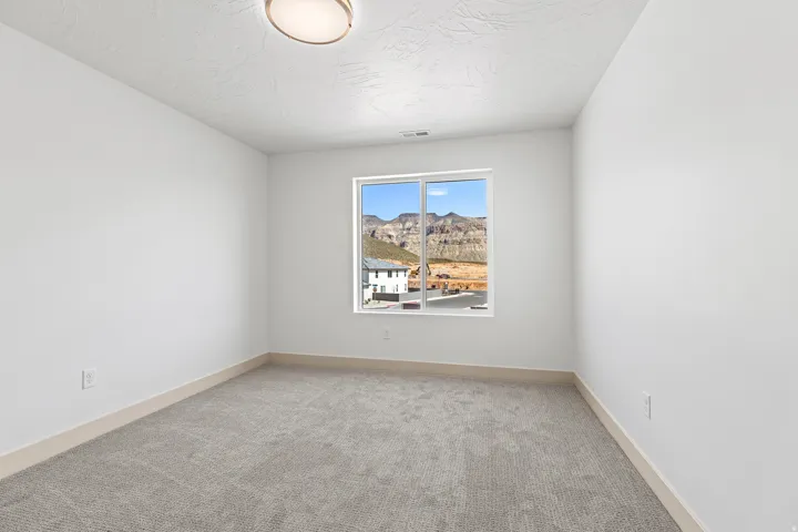 Unfurnished room featuring light carpet and baseboards