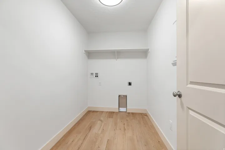 Laundry room featuring light wood-type flooring, hookup for a washing machine, and hookup for an electric dryer
