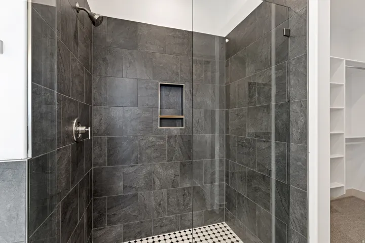 Bathroom featuring a stall shower and a spacious closet