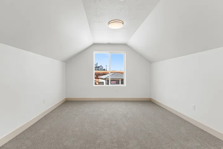 Bonus room with carpet flooring and baseboards