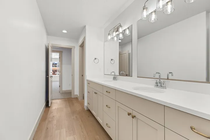 Bathroom featuring double vanity, light wood-style floors, and recessed lighting