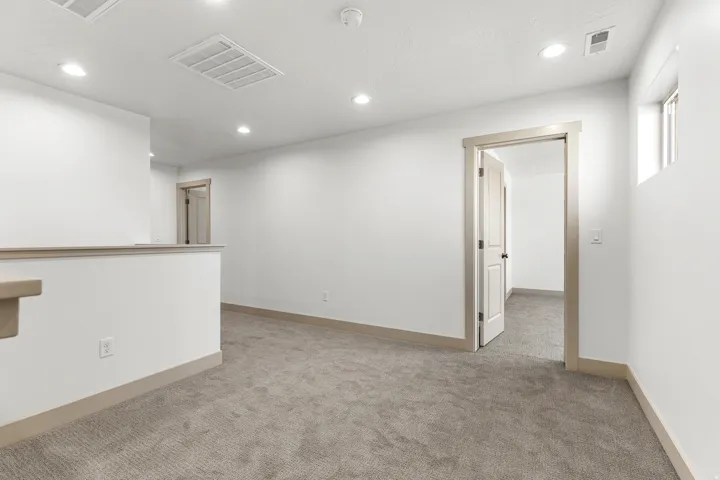 Unfurnished room with light colored carpet and recessed lighting