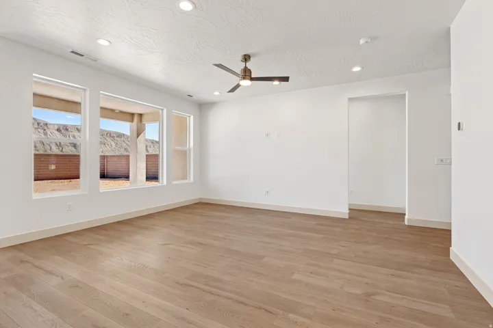 Empty room featuring a ceiling fan, light wood-style floors, and recessed lighting