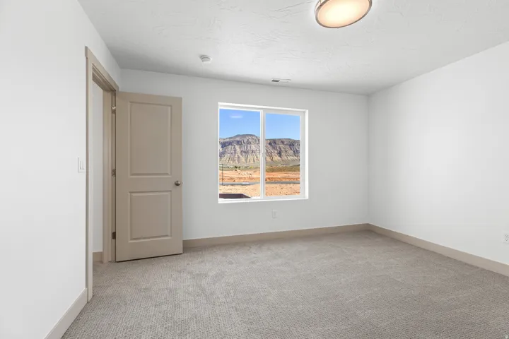 Spare room featuring a mountain view and light carpet