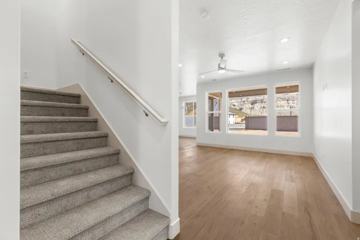 Stairway featuring recessed lighting, wood-type flooring, and a ceiling fan