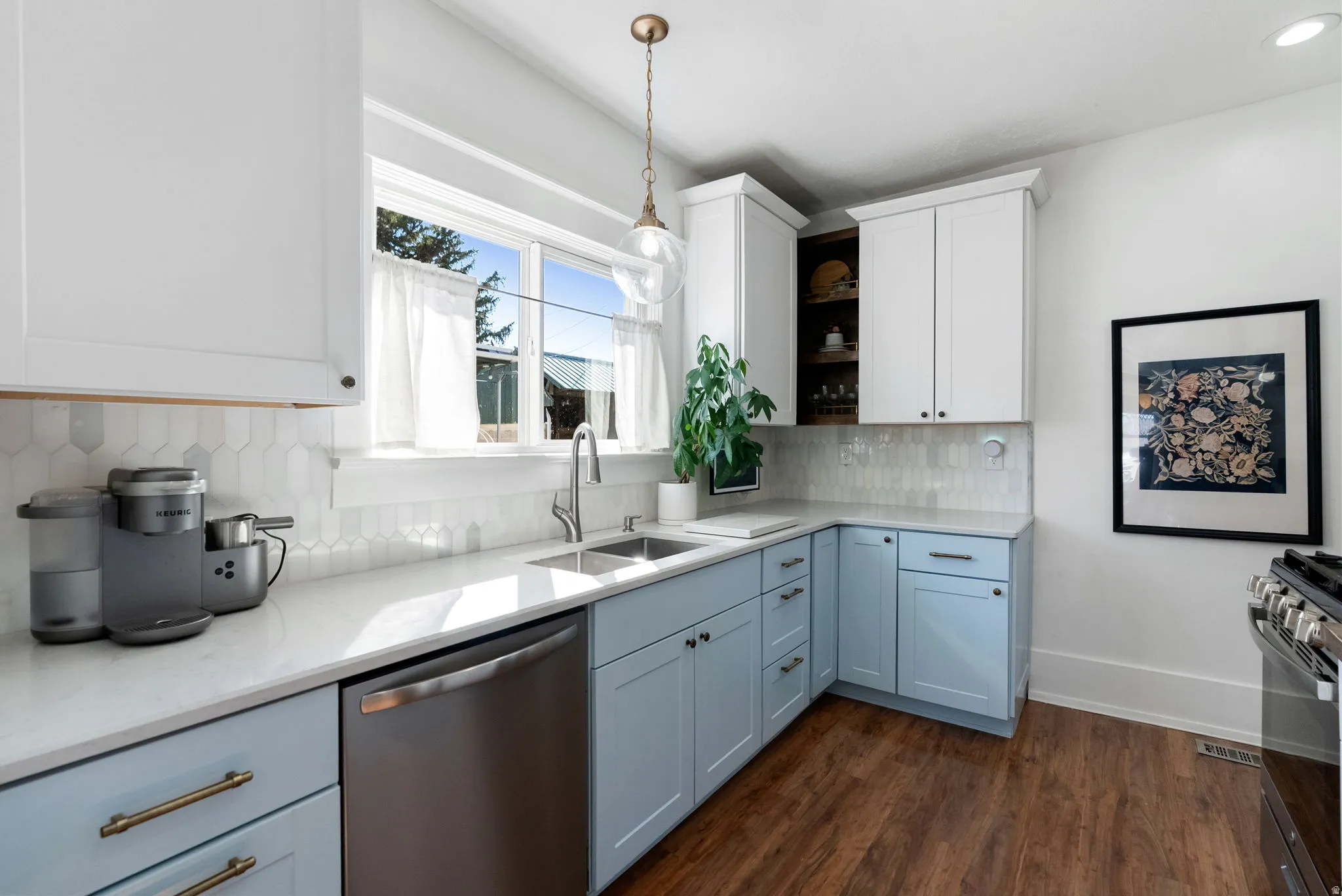 Kitchen with stainless steel appliances, open shelves, dark wood-style flooring, light stone countertops, and hanging light fixtures