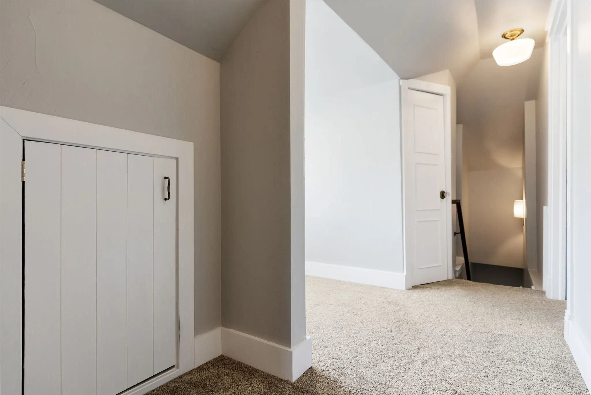 Additional living space featuring light carpet and lofted ceiling