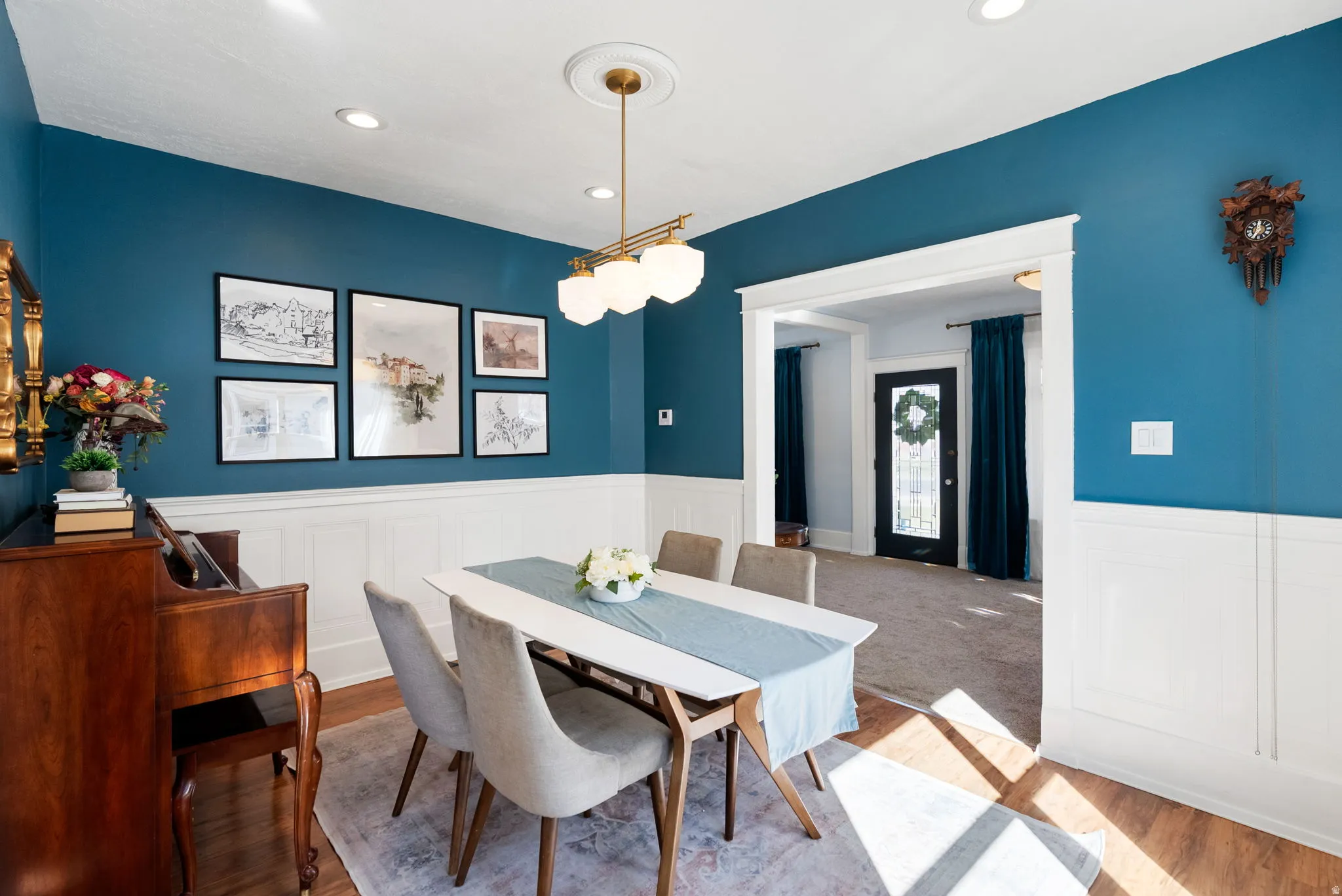 Dining room with wood finished floors, wainscoting, and recessed lighting