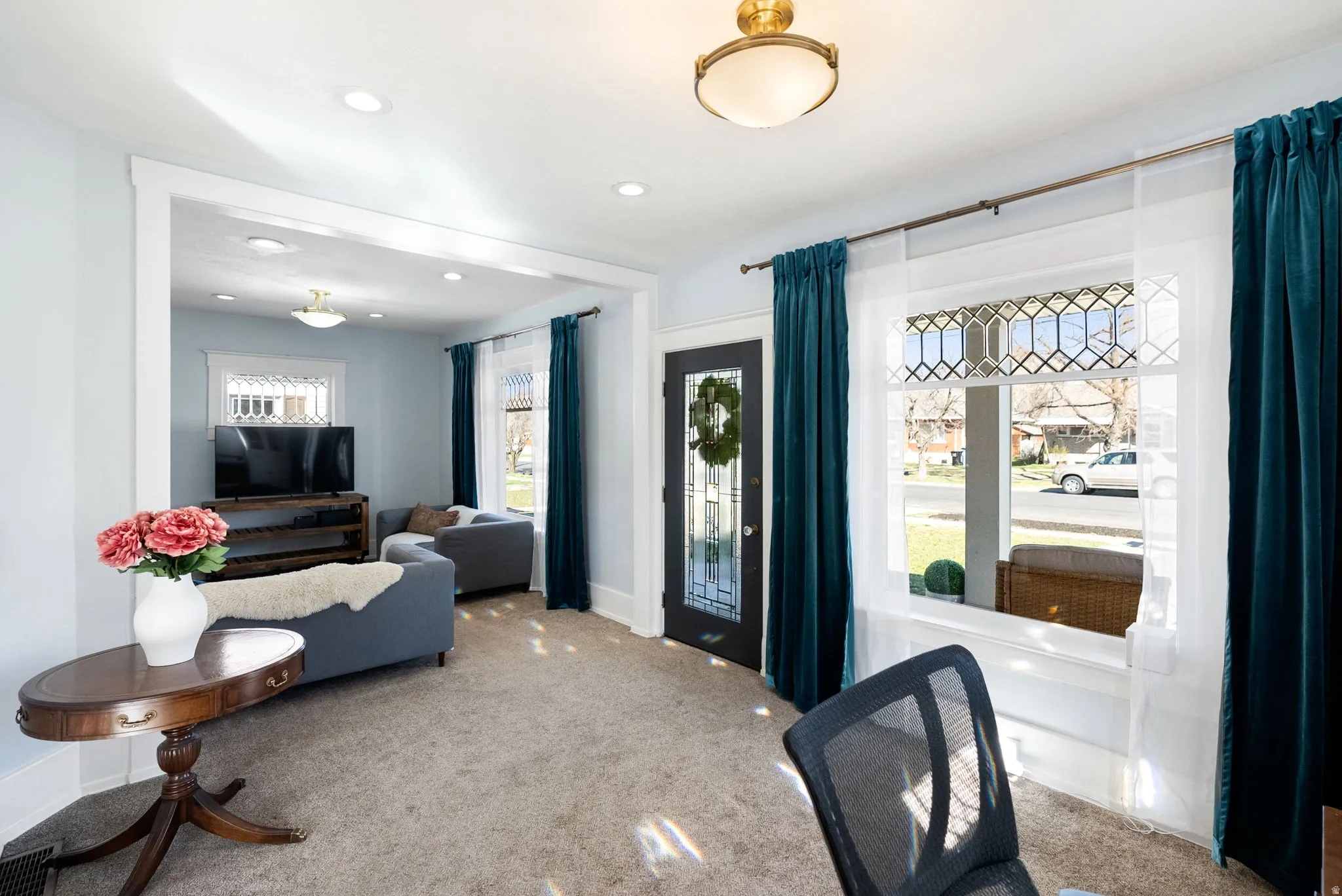 Living area with recessed lighting and light carpet