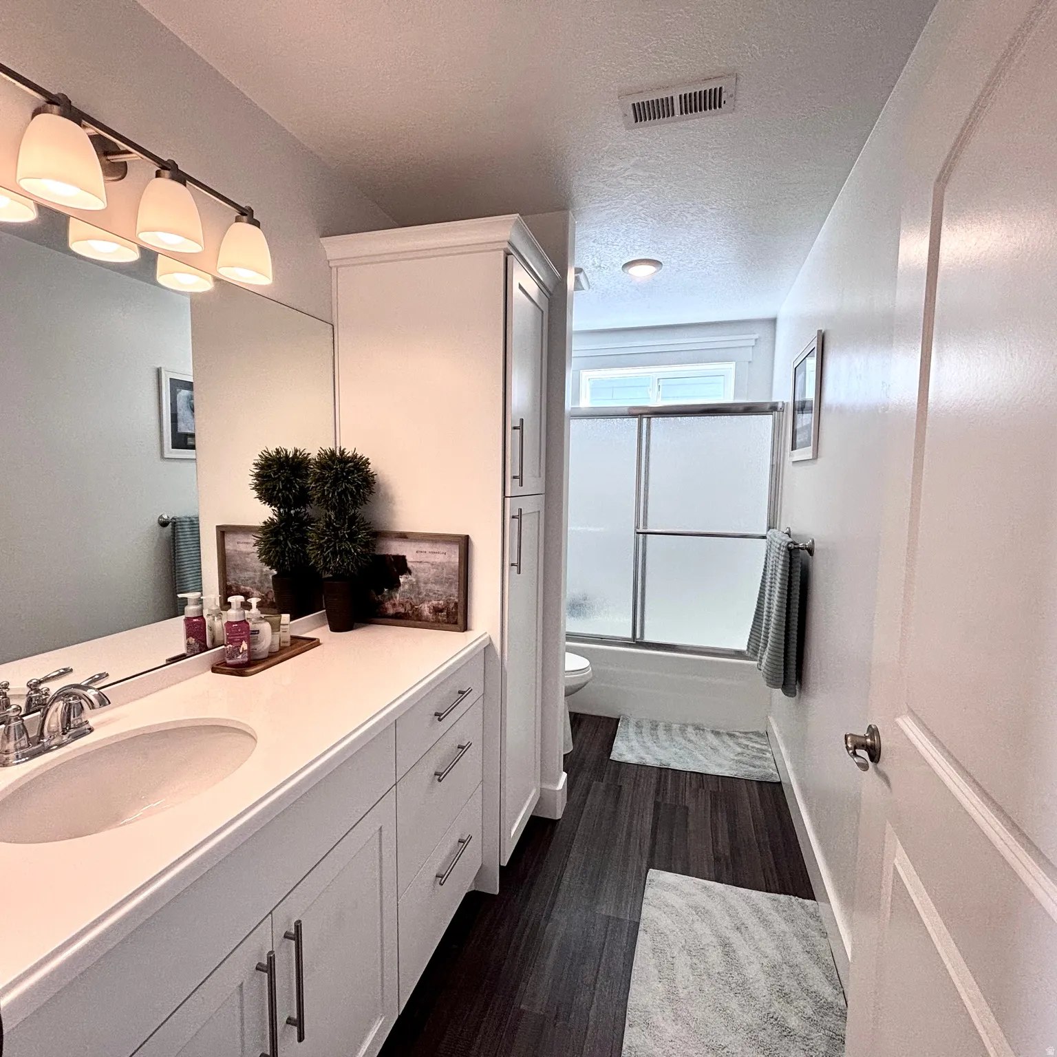 Bright bathroom #1 featuring a large vanity, generous cabinetry/storage, and a clean, modern feel.